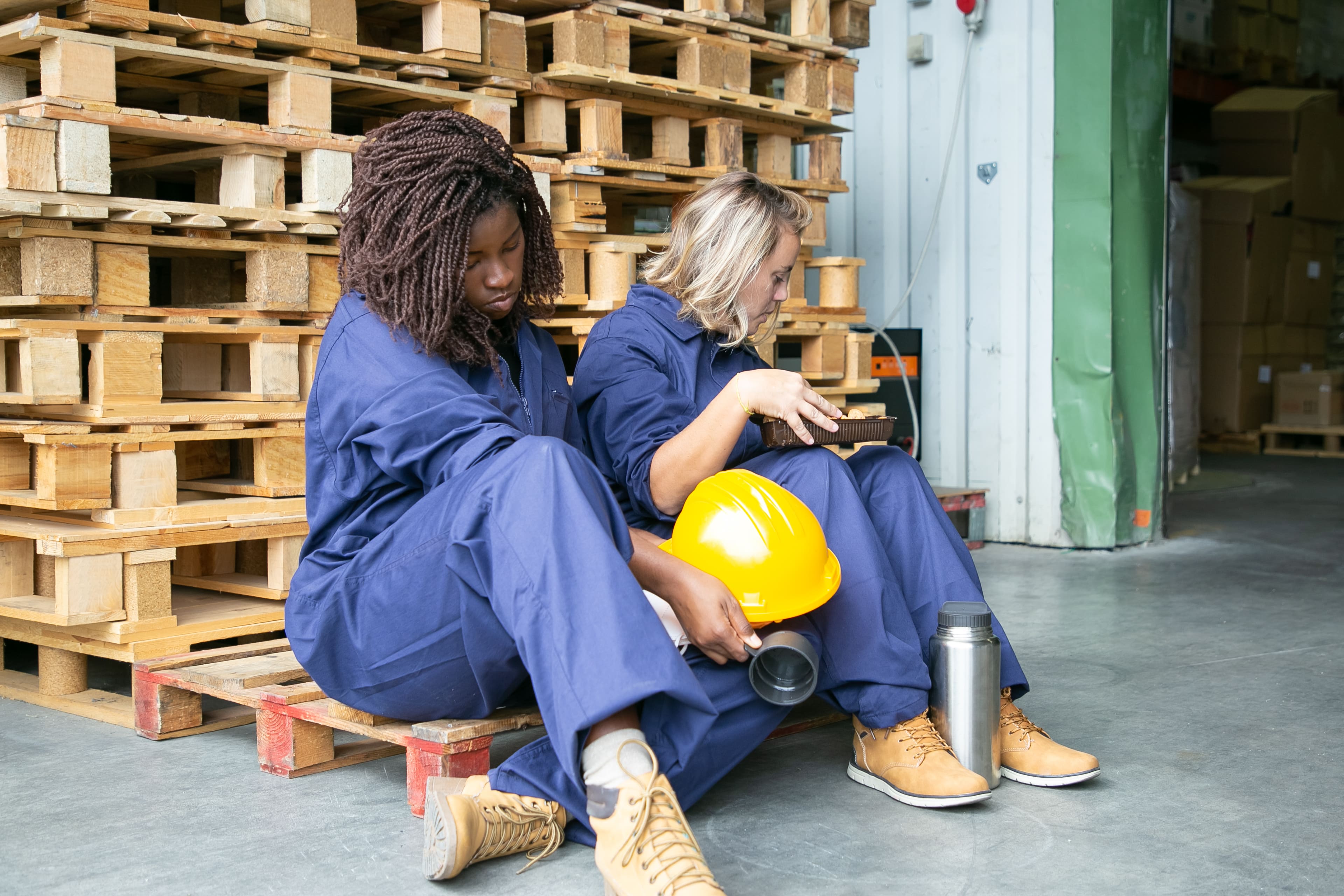 Worker sitting beside pallets
